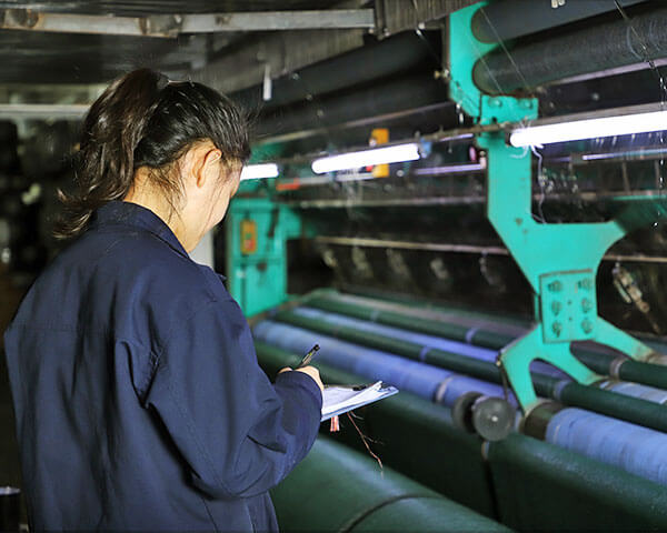 A worker is recording production beside the machine